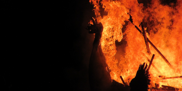 Imagem de uma fogueira, onde se pode ver as madeiras alimentando a chama. 